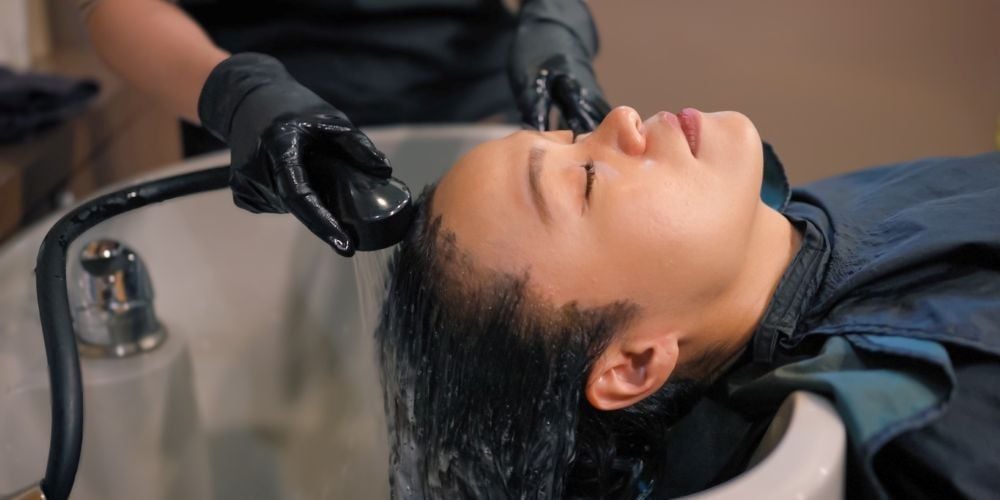 Woman getting her hair shampooed.